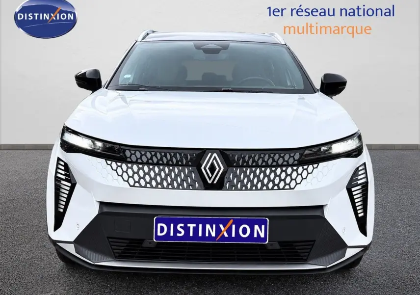 Vue de face du Renault Scénic 5 blanc électrique 2024 avec calandre à motif nid d'abeille et phares fins LED.