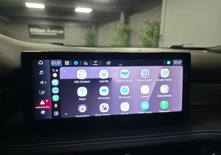 Écran tactile central affichant Android Auto dans l'habitacle de l'Alfa Romeo Tonale rouge, vue intérieure frontale.