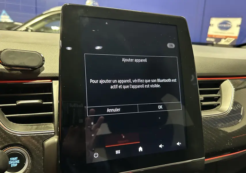 Écran tactile central du tableau de bord d’un Renault Arkana noir, avec message d’ajout d’appareil Bluetooth visible.