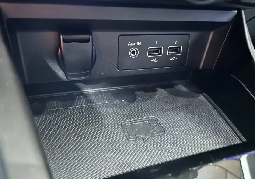 Gros plan sur la console centrale noire du Renault Arkana, montrant les ports Aux-IN et deux prises USB.