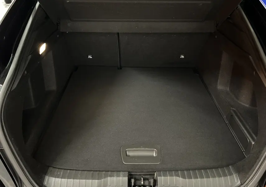 Coffre ouvert vu de face du Renault Arkana noir, montrant un espace de chargement propre et bien éclairé.