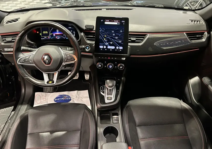 Vue intérieure avant du Renault Arkana noir E-Tech 145ch RS Line avec volant sport, écran tactile vertical et sièges cuir noirs.