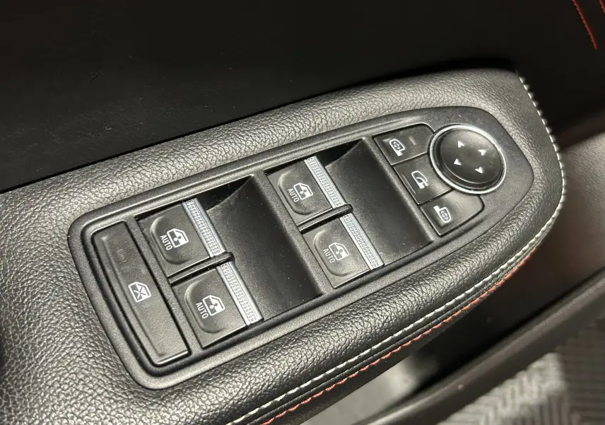 Gros plan sur les commandes de lève-vitres et rétroviseurs électriques sur la porte côté gauche du Renault Arkana noir.