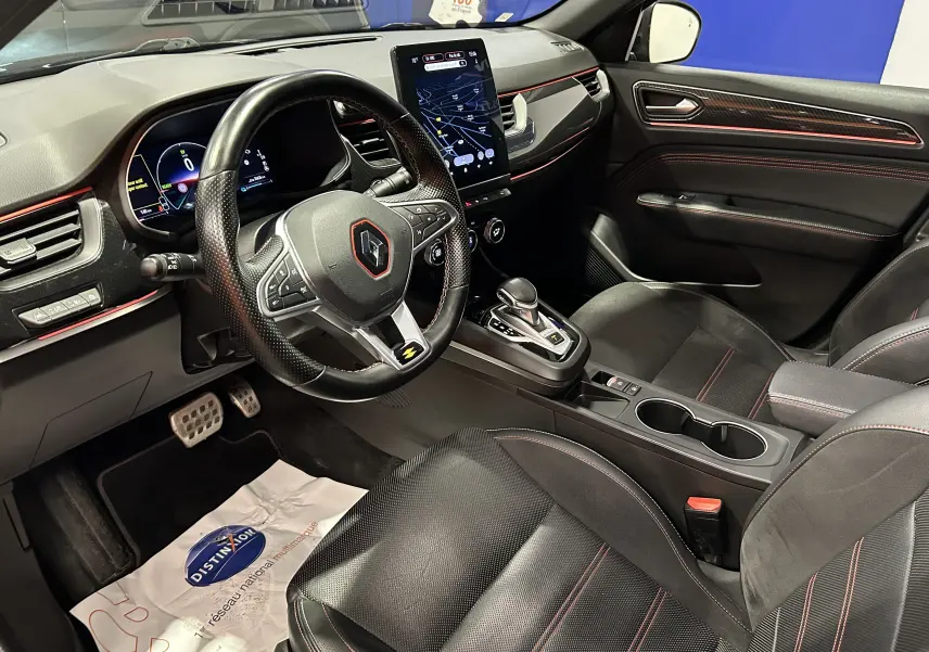 Vue intérieure côté conducteur de la Renault Arkana E-Tech noire, volant sport et écran tactile central avec finition RS Line.