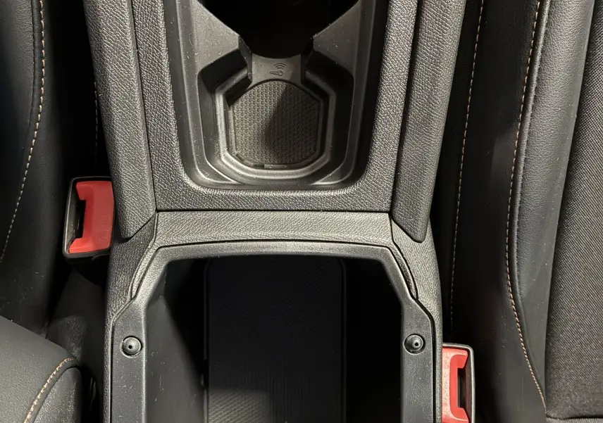 Vue plongeante sur la console centrale noire du CUPRA Formentor 1.4 E-HYBRID 2023, avec porte-gobelet et prise 12V visible.