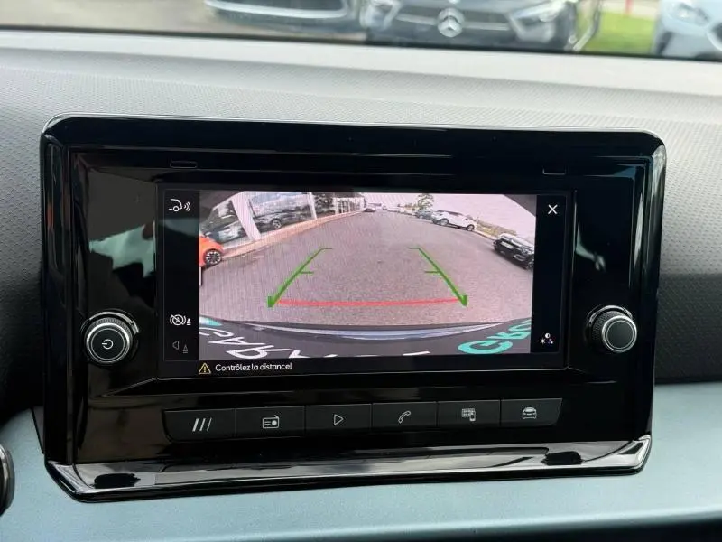 Écran central affichant la caméra de recul du SEAT Arona 2025, vue arrière avec lignes de guidage vertes et rouges.