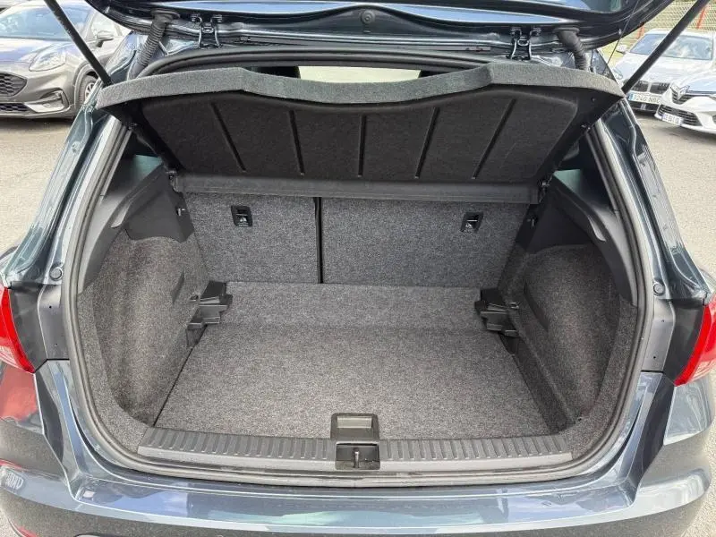 Coffre ouvert vu de l'arrière d'un SEAT Arona 2025 gris Magnétique Métal, montrant l'espace de chargement vide.