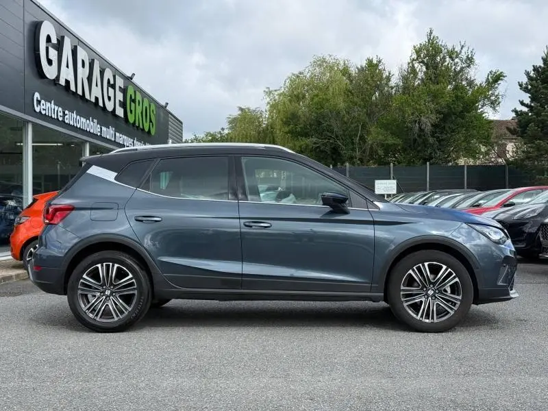 Vue de profil côté gauche d'un SEAT Arona 2025 gris magnétique métal, soulignant ses lignes modernes et ses jantes alliage.