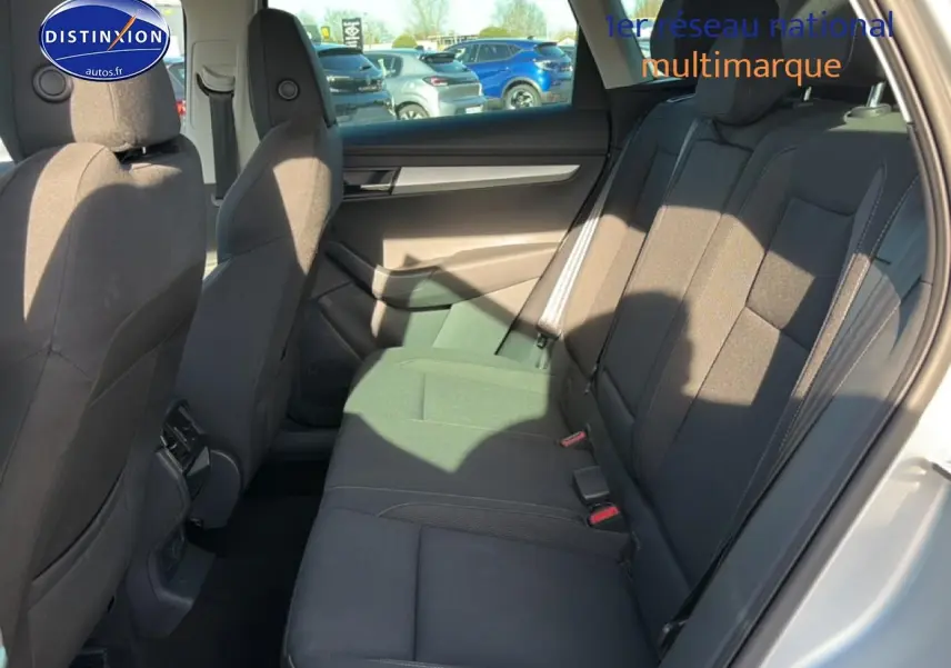 Vue intérieure côté droit sur la banquette arrière noire du Skoda Karoq gris avec appuie-têtes et ceintures visibles.