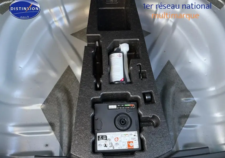 Détail du coffre gris d’un Skoda Karoq 1.5 TSI 2025 montrant le kit de réparation pneus intégré.