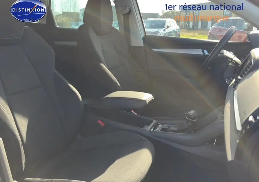 Intérieur avant du Skoda Karoq gris 2025, vue côté droit sur sièges et console centrale avec accoudoir.
