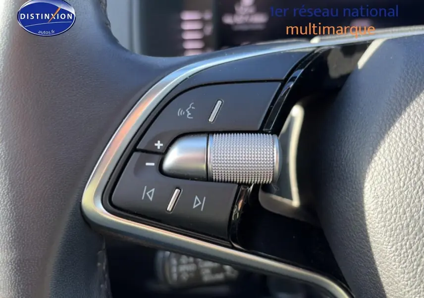 Gros plan sur les commandes audio au volant cuir du Skoda Karoq gris, version 1.5 TSI 150 DSG7, 2025.