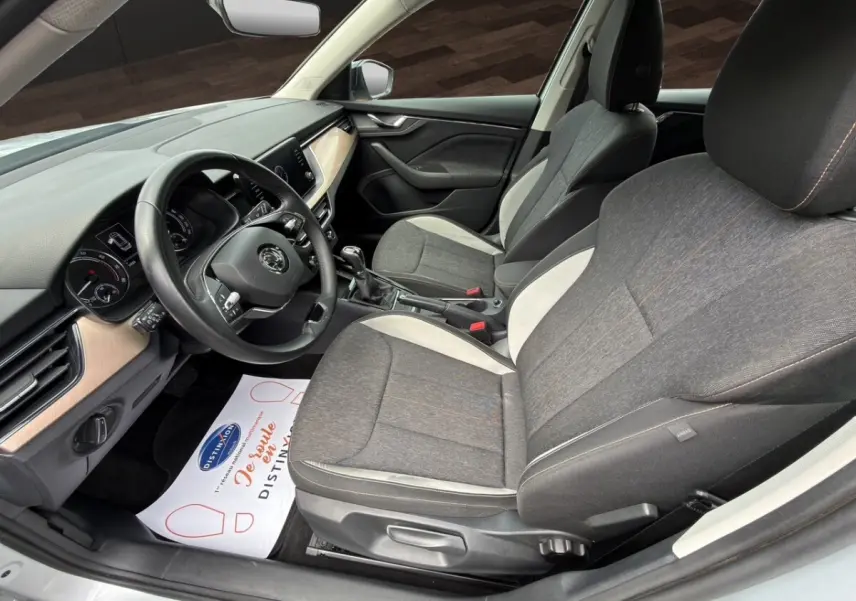 Intérieur avant droit du Skoda Kamiq gris clair 2023, sièges tissu bicolore et tableau de bord avec écran tactile.
