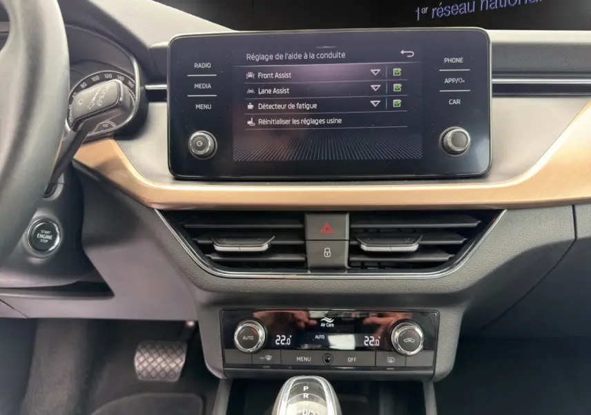 Tableau de bord et console centrale du Skoda Kamiq 2023 avec écran tactile, climatisation digitale et bouton start/stop.