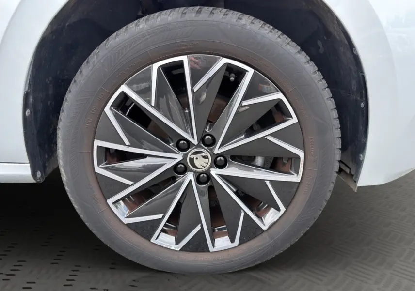 Gros plan sur la jante bi-ton noire et argentée d'une Skoda Kamiq gris clair, roue avant droite.