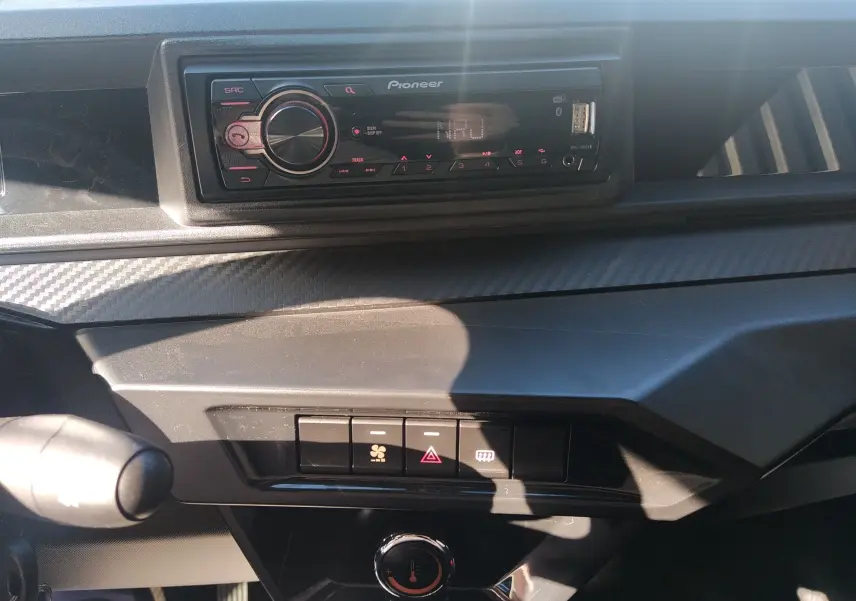 Vue rapprochée de la planche de bord noire avec autoradio Pioneer et commandes de ventilation du Ligier JS60 Revo D+ Select.