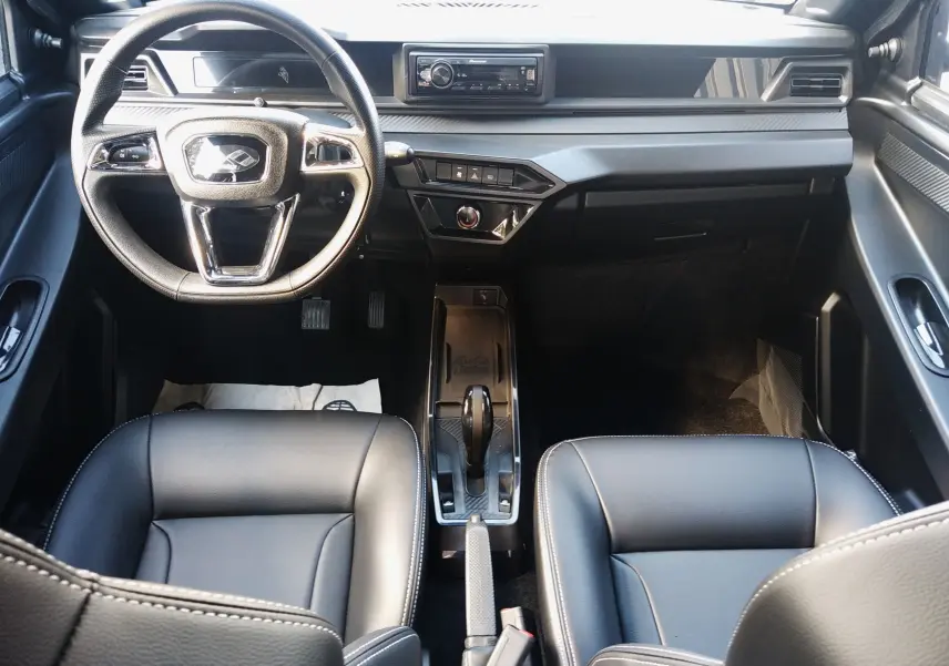 Vue intérieure avant de la Ligier JS60 Nouvelle Revo D+ Select, sièges noirs, volant chromé et console centrale avec boîte auto.