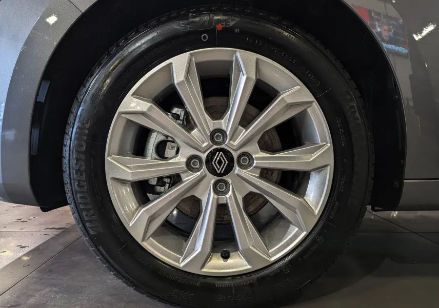 Gros plan sur la jante alliage argentée de la Renault Clio V Gris Schiste, avec logo Renault au centre.