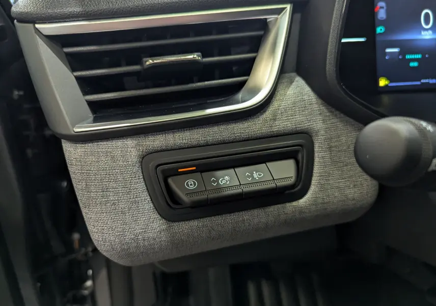 Détail du tableau de bord côté gauche de la Renault Clio V Blue dCi 100 CH Evolution 2025 avec tissu gris schiste et commandes éclairage.