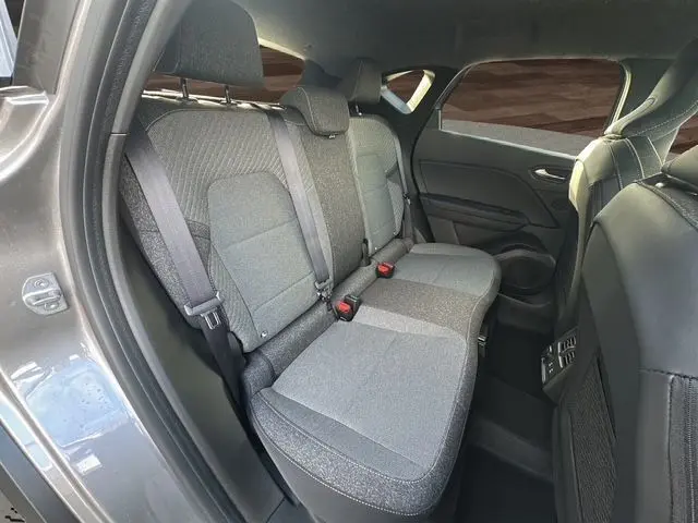 Vue intérieure arrière côté gauche du Renault Captur 2025 gris Cassiopée, montrant les sièges arrière en tissu bi-ton.
