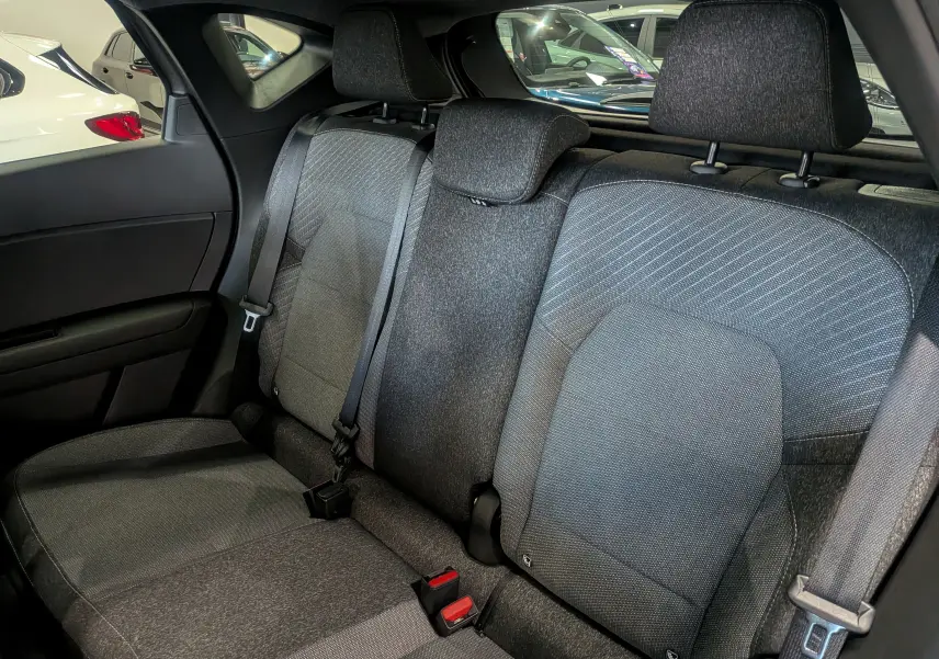Vue intérieure des sièges arrière en tissu gris du Renault Captur 2025, avec ceintures de sécurité visibles.