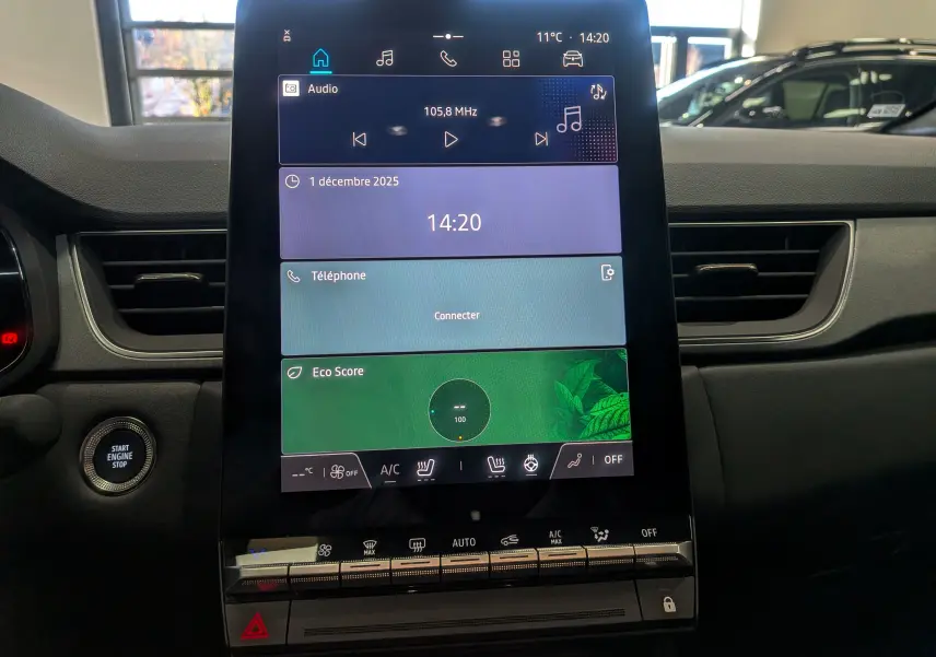 Écran tactile central allumé du tableau de bord du Renault Captur 2025, avec bouton Start Engine à gauche.
