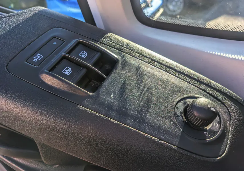 Gros plan sur les commandes de lève-vitres et réglage des rétroviseurs côté conducteur du Fiat Ducato Fourgon blanc.