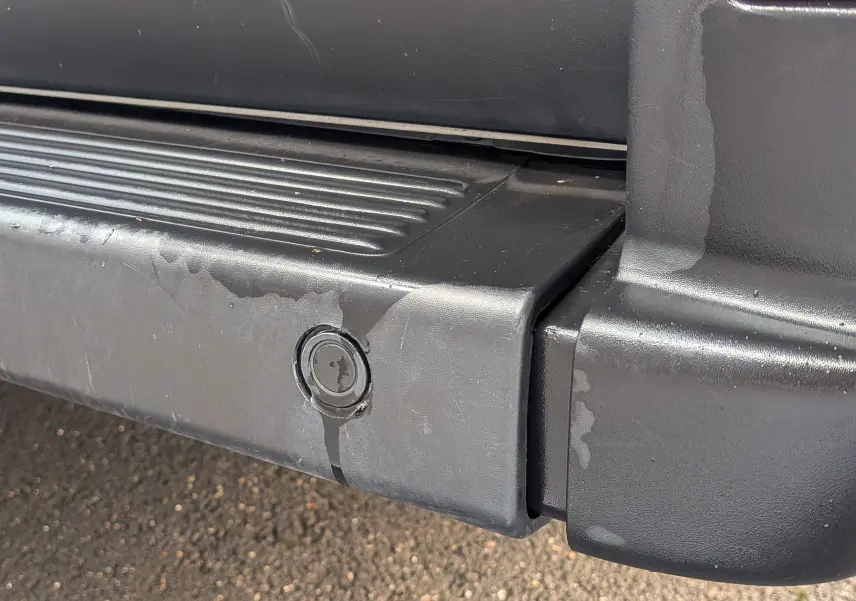 Gros plan sur le pare-chocs arrière noir du FIAT Ducato Fourgon blanc, montrant un capteur de stationnement intégré.