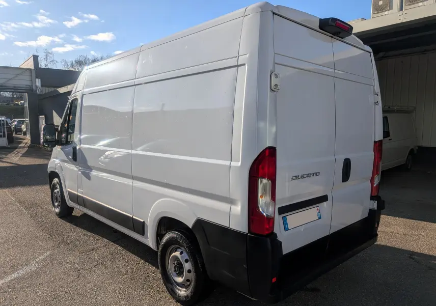 Vue 3/4 arrière droite d’un FIAT Ducato Fourgon blanc 2022, avec portes arrière fermées et pare-chocs noir.