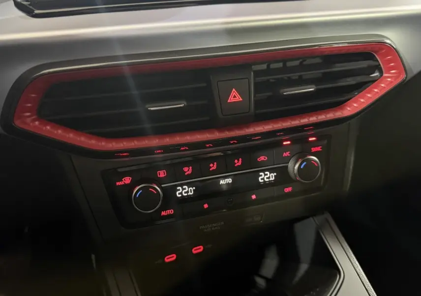 Détail du tableau de bord de la SEAT Ibiza 1.0 TSI 110 FR 2024, avec ventilation et commandes climatisation rouges.