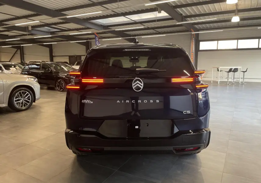 Vue arrière d'un Citroën C5 Aircross bleu Azul avec feux arrière LED allumés dans un showroom.