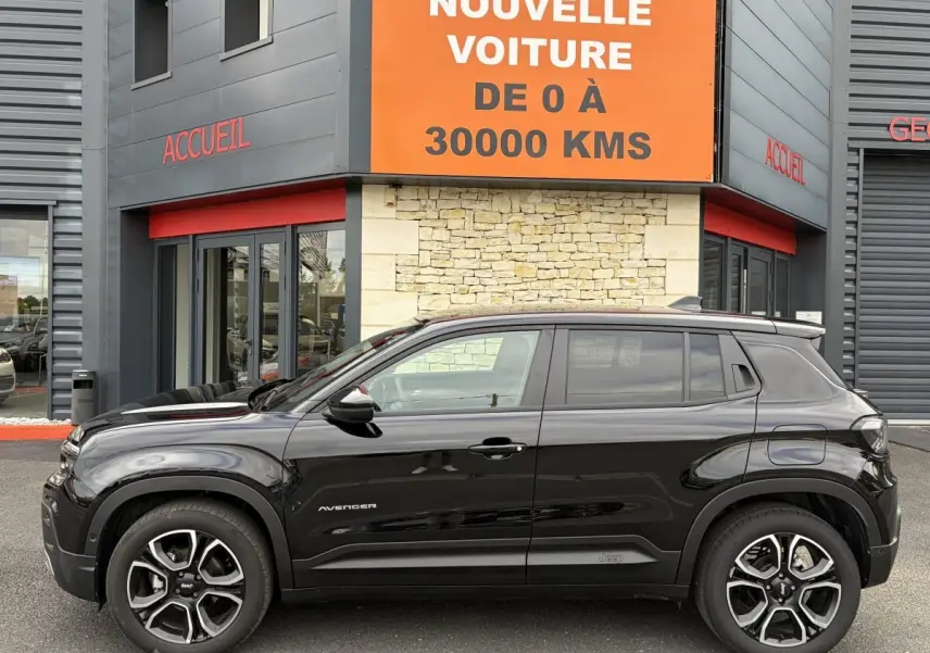 Vue de profil côté gauche d'un Jeep Avenger noir 2025 garé devant un bâtiment avec panneau orange.
