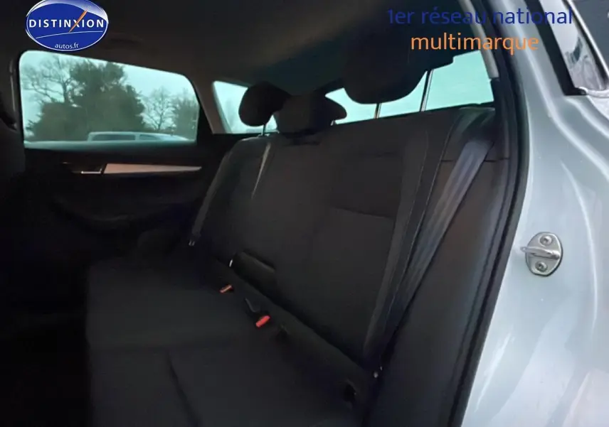 Vue intérieure côté droit sur la banquette arrière noire du Skoda Karoq blanc glacial avec porte ouverte.