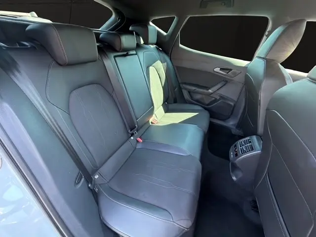 Vue intérieure côté droit des sièges arrière noirs en cuir du CUPRA Formentor blanc, avec console de ventilation centrale visible.