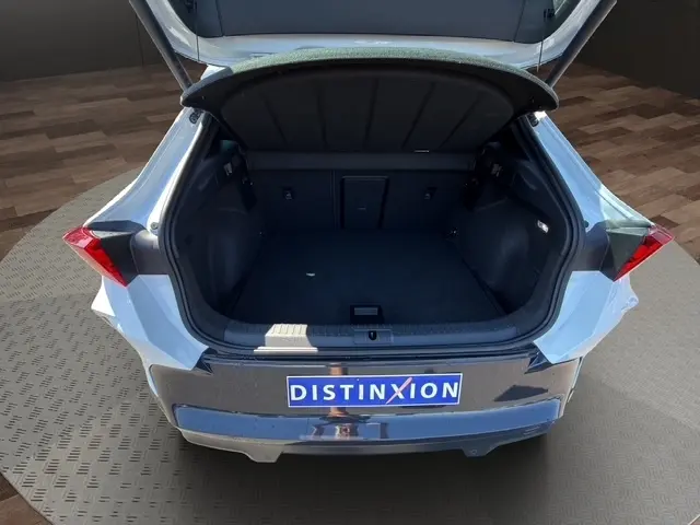 Vue arrière du coffre ouvert d'une CUPRA Formentor blanc 2025, montrant l'espace de chargement vide et la plaque Distinxion.