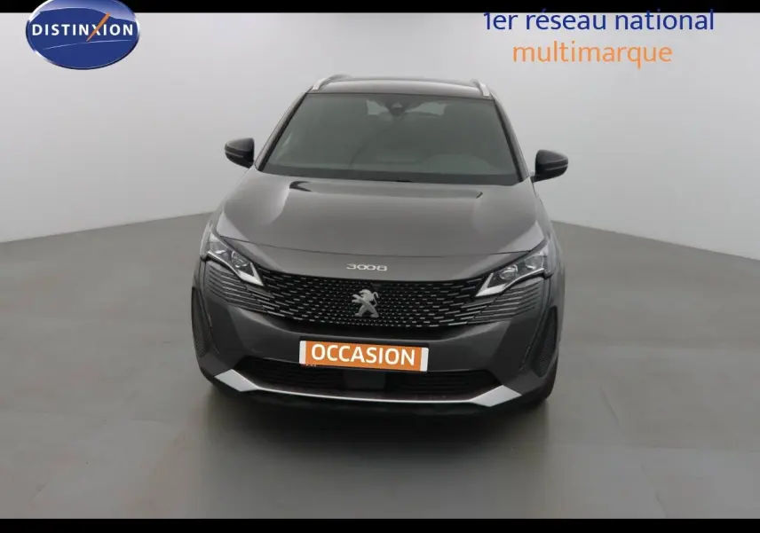 Vue frontale d'un Peugeot 3008 gris platinium métal avec calandre noire et logo lion central bien visible.