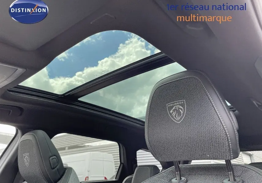 Vue intérieure du Peugeot 5008 Hybrid 136ch GT 2025, toit panoramique et appuie-tête avant en tissu noir brodé Peugeot.