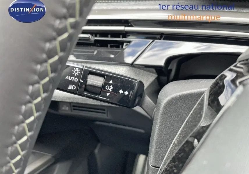 Gros plan sur la commande d'éclairage à gauche du volant dans l'habitacle du Peugeot 5008 Hybrid 2025.
