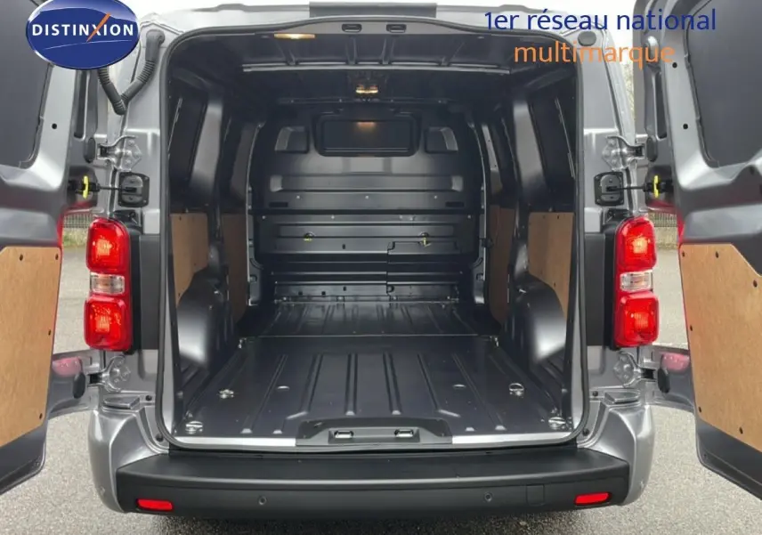 Vue arrière du Citroën Jumpy gris Artense avec portes ouvertes montrant l’espace de chargement vide et les panneaux boisés.