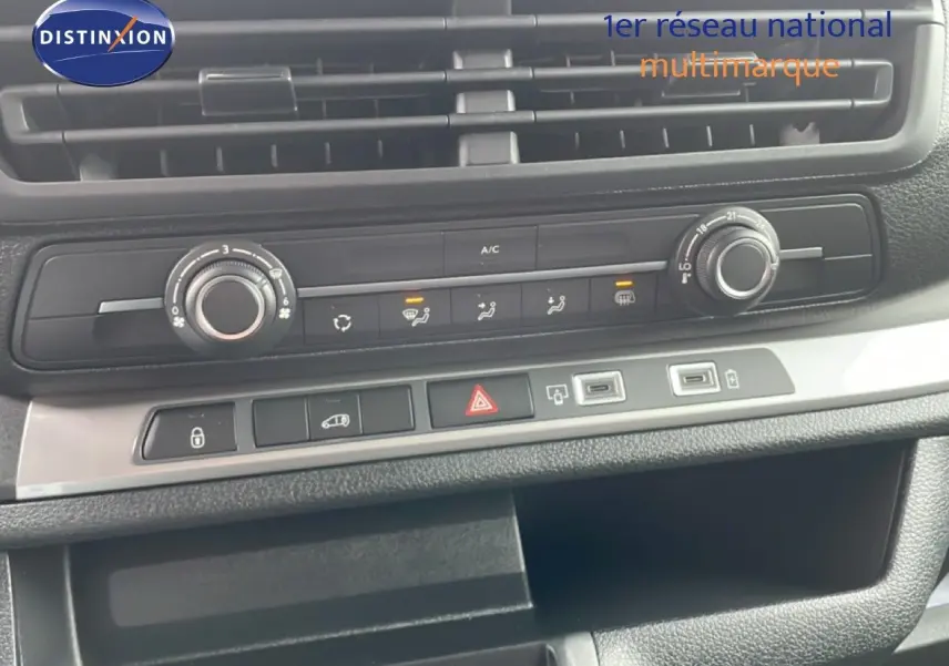 Vue rapprochée de la console centrale du Citroën Jumpy gris Artense, montrant les commandes de climatisation et ports USB.