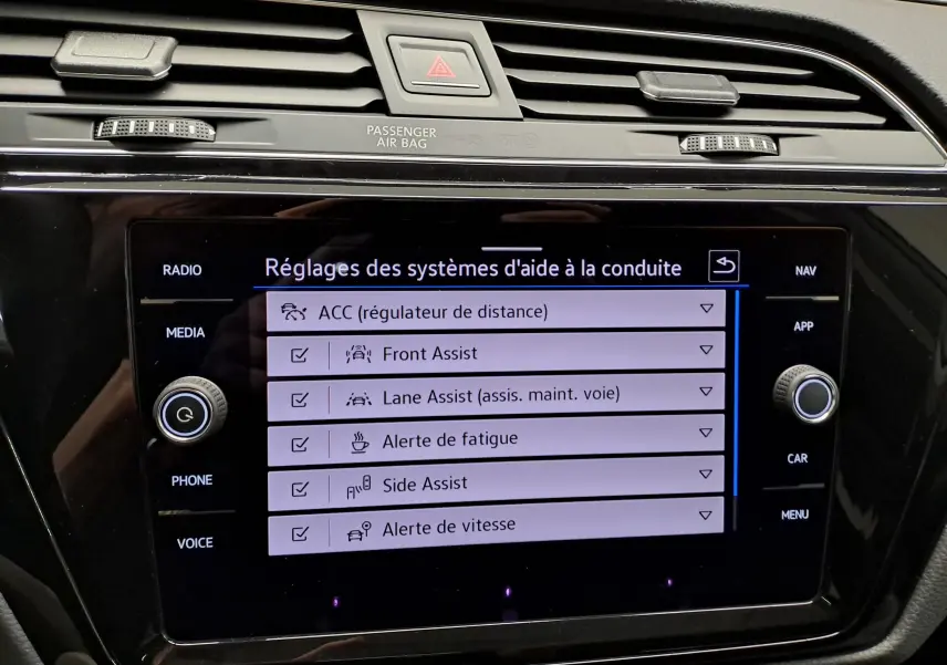 Vue de profil côté gauche d'un Volkswagen Touran gris argent avec jantes alliage et toit ouvrant panoramique.