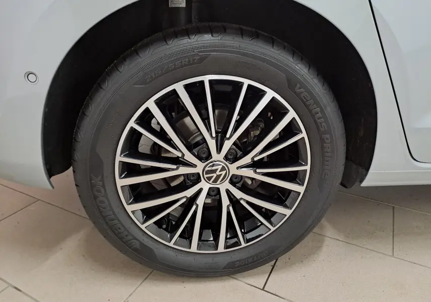 Gros plan sur la roue avant droite gris argent du Volkswagen Touran 2025 avec jante alliage noire et argentée.