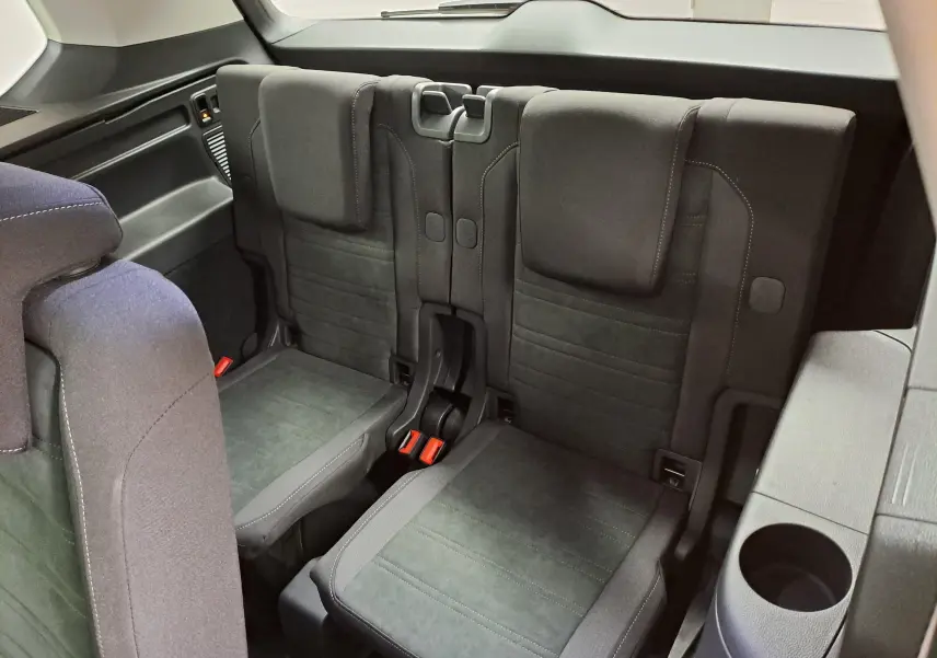 Vue intérieure arrière du Volkswagen Touran 2025 montrant les deux sièges de la troisième rangée en tissu gris foncé.