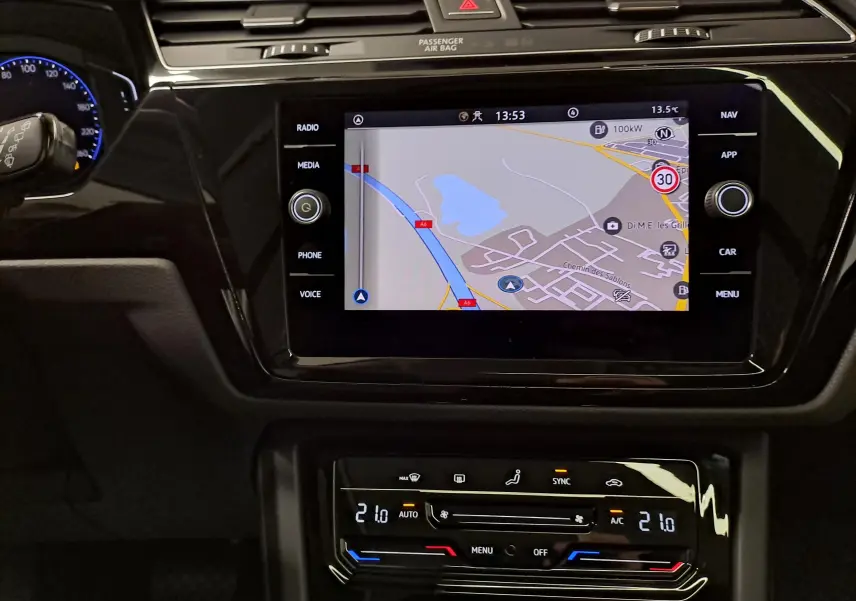 Vue rapprochée de l’écran tactile central et de la console de climatisation du Volkswagen Touran gris argent, intérieur moderne et épuré.