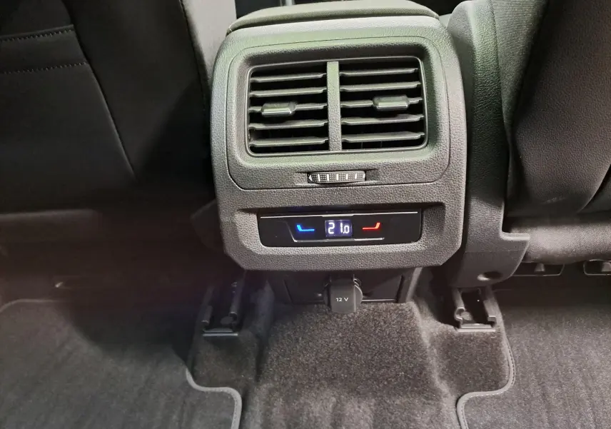 Vue rapprochée de la console arrière avec ventilation et réglage de température digitale à 21°C dans un Volkswagen Touran.