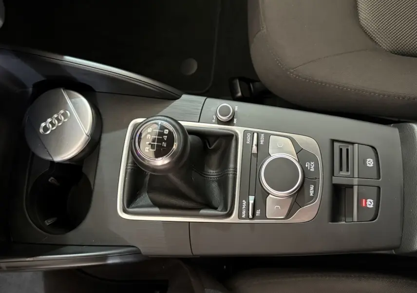 Vue rapprochée du levier de vitesses manuel et de la console centrale noire d’une Audi A3 bleu 2018.