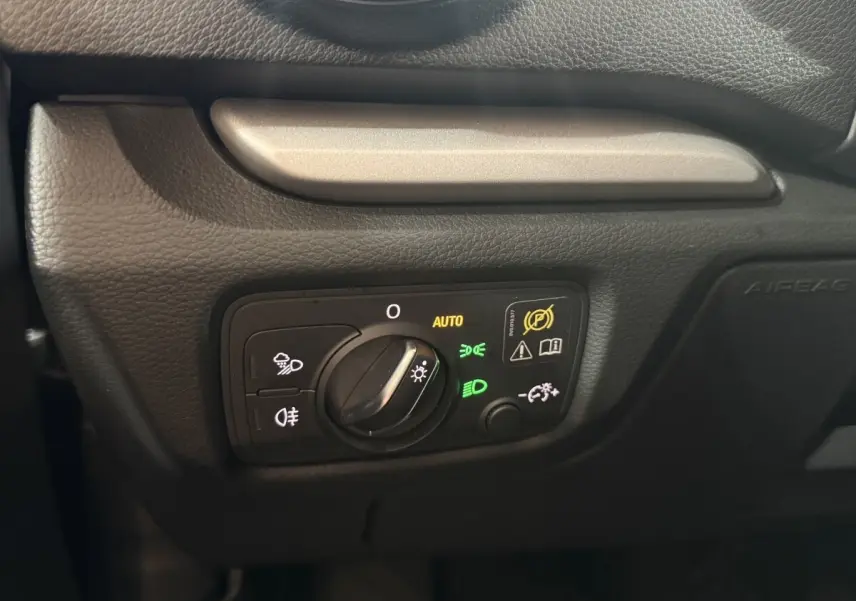 Gros plan sur le panneau de commande des phares et feux antibrouillard dans l'habitacle d'une Audi A3 bleu 2018.