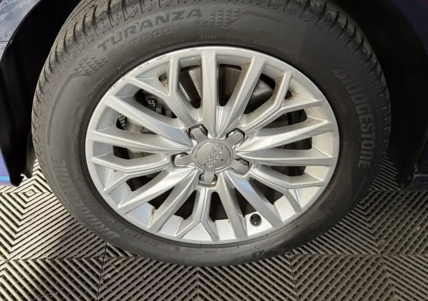 Gros plan sur la jante argentée et le pneu Bridgestone Turanza d'une Audi A3 bleu, côté avant gauche.