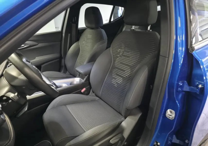 Vue intérieure côté conducteur de l'Alfa Romeo Tonale bleu 2025, sièges tissu noir avec surpiqûres beige et accoudoir central.