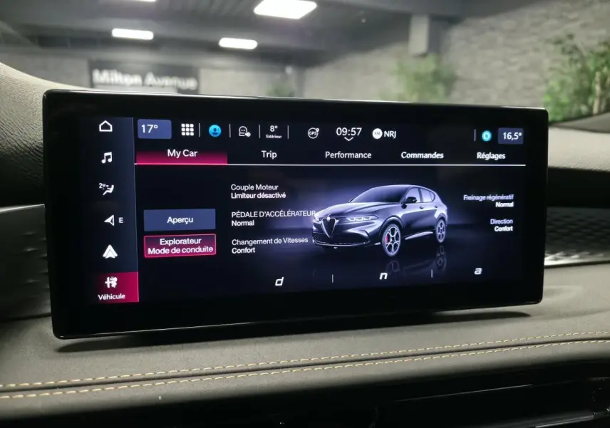 Écran tactile intérieur affichant une Alfa Romeo Tonale bleue en vue 3/4 avant avec paramètres de conduite.